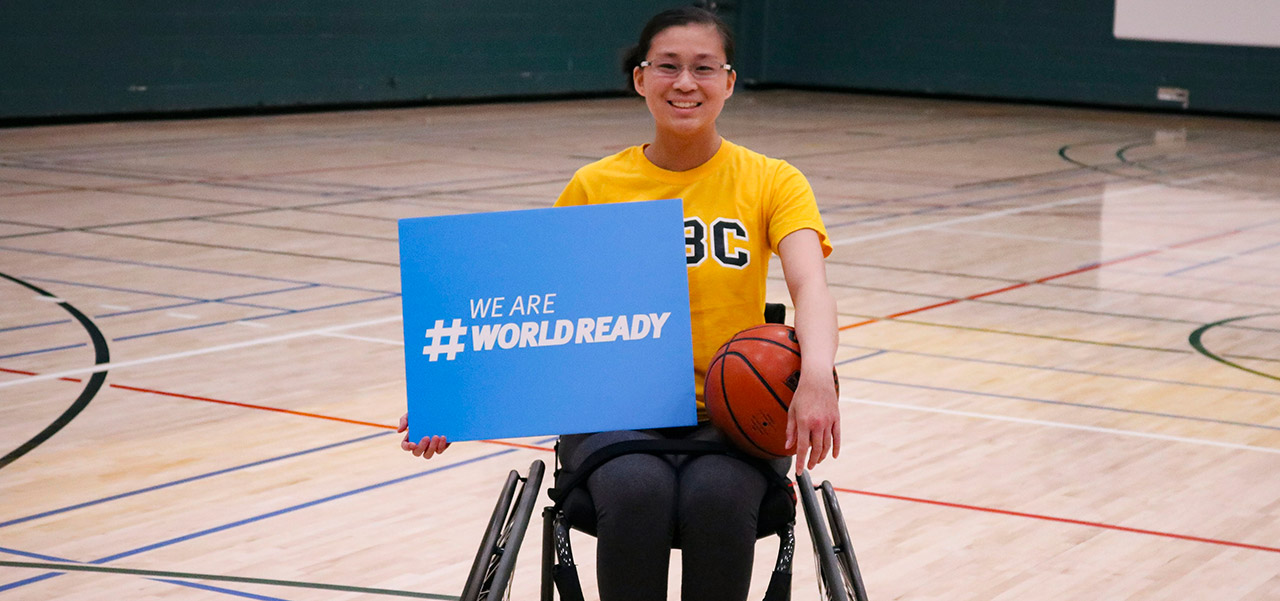 Young woman in wheelchair holding a sign