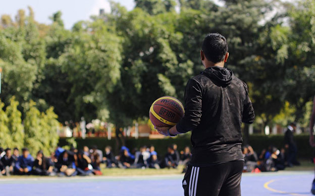 Award participant playing basketball in front of a crowd